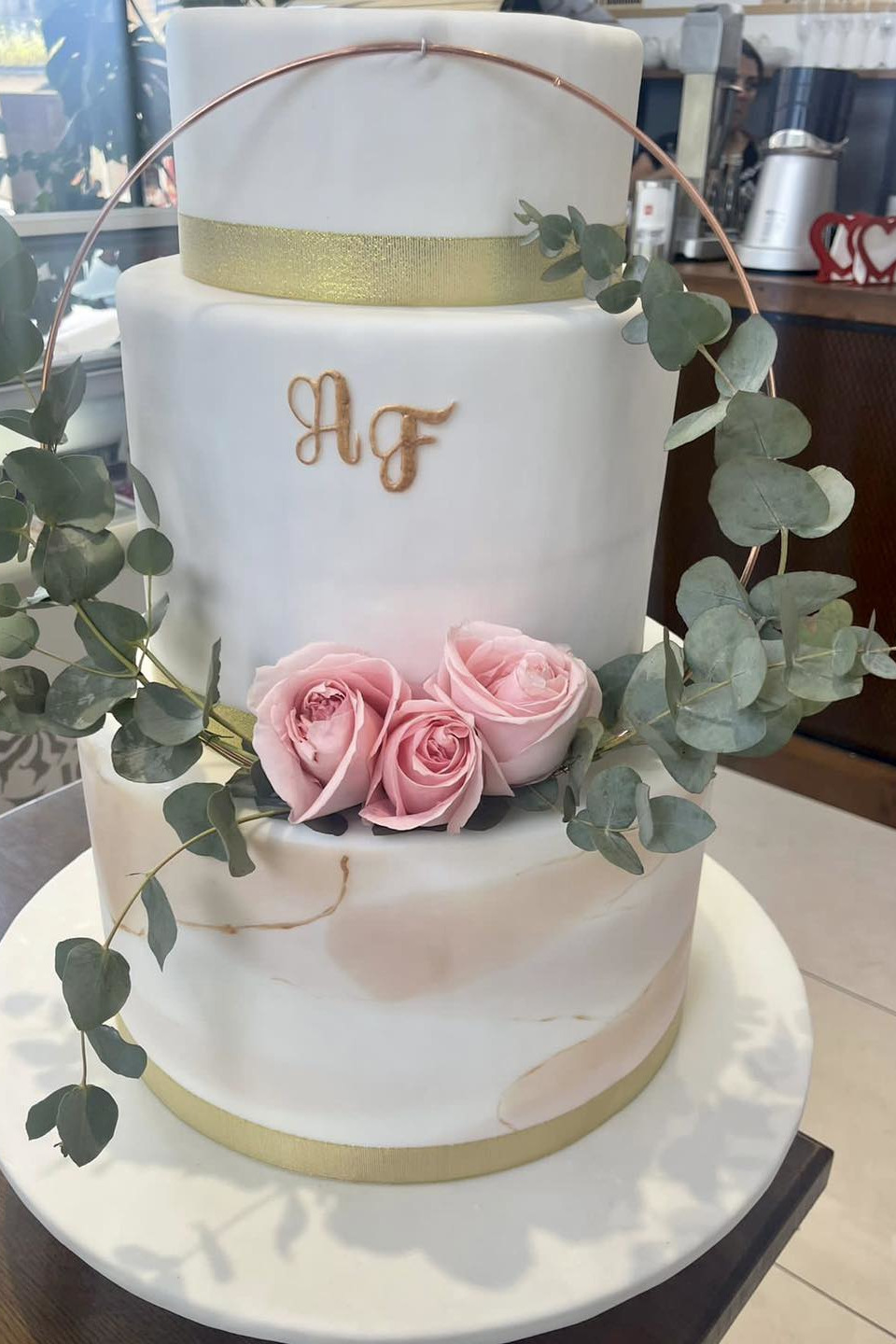 Detaliu decor tort de nuntă cu flori naturale și macarons